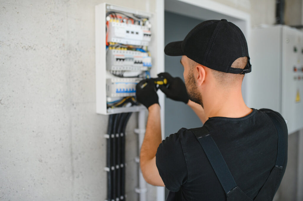 Elektriker arbeitet an einem Sicherungskasten – Karriere bei KOWO Wohnen im Eichsfeld